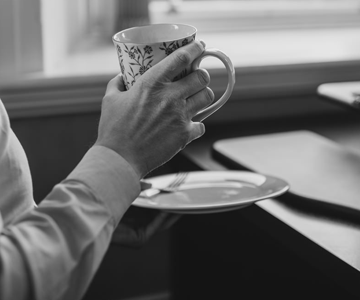 Hands holding a cup and saucer